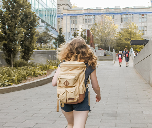 Person with backpack walking away from camera