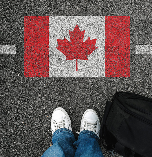 Feet facing the Canadian Flag on asphalt 