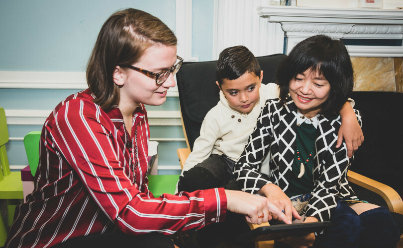 Two adults and a child looking at a tablet