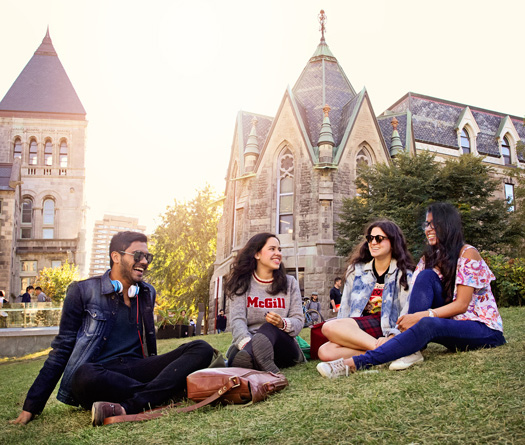 Four students sitting on the front lawn of McGill campus.