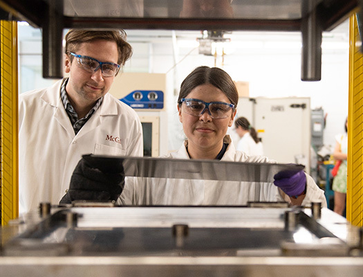 Two people wearing goggles and white coats