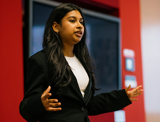 A woman talking in front of a red wall