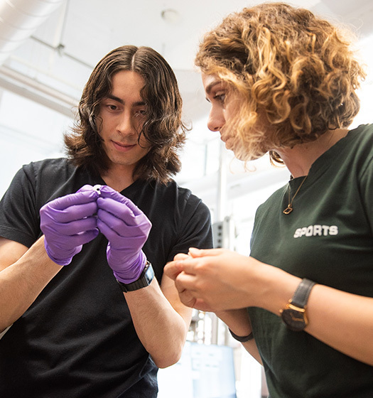 Male student with purple gloves and woman student