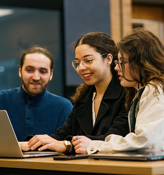 Three students around a computer