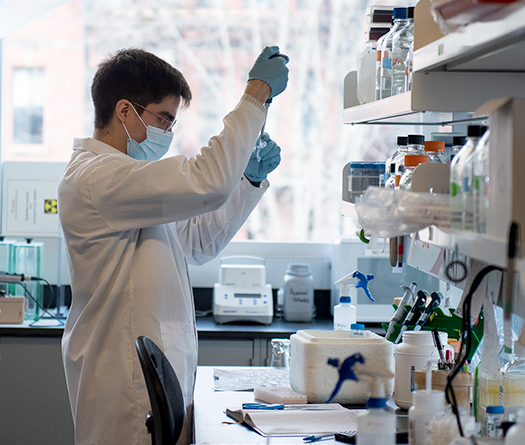 A man wearing a mask and gloves in a laboratory