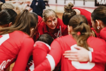 Woman coach in huddle with players