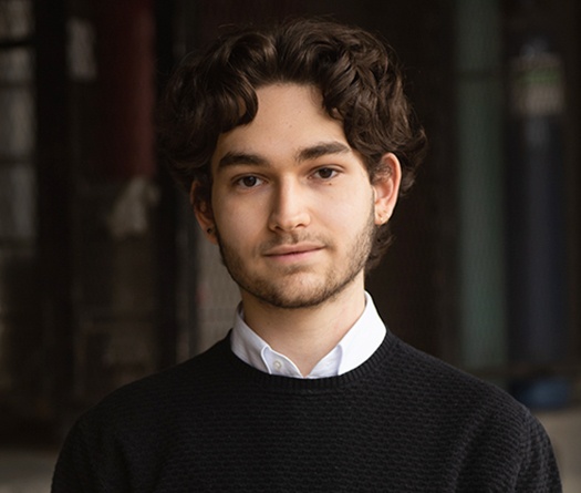 A person with curly hair wearing a black sweater