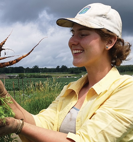 Kayla Dowd holding a bunch of carrots