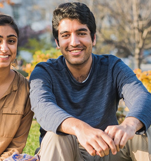 Two students in front of an autumn background