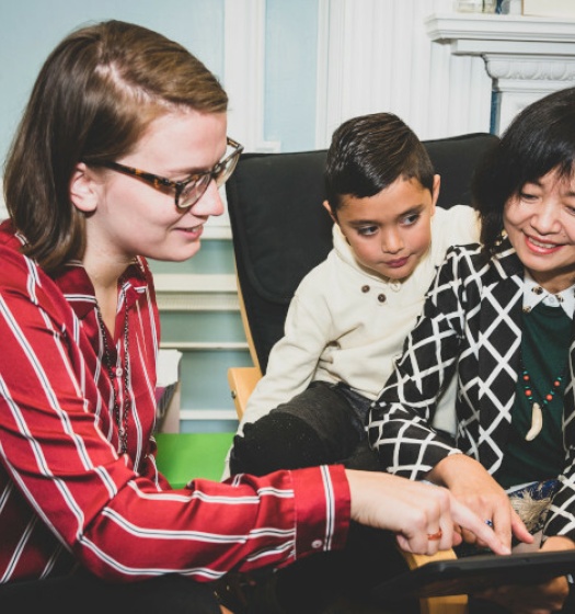 Two adults and a child looking at a tablet