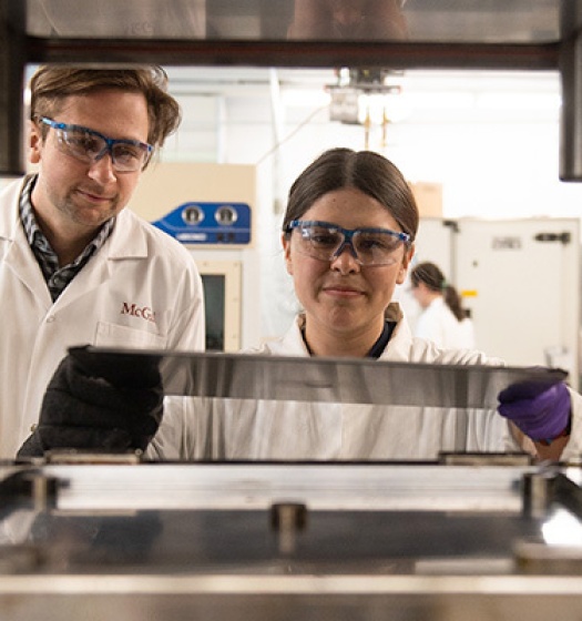 Two people wearing goggles and white coats