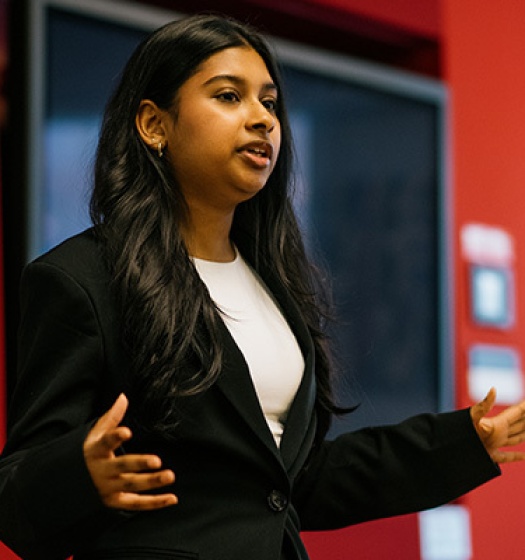A woman talking in front of a red wall